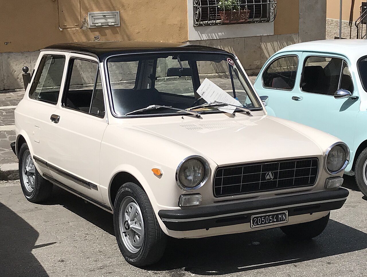Autobianchi: Das kleine Labor, in dem Fiat seine verrücktesten Ideen testete

Bevor eine Idee bei Fiat in Serie ging, musste sie sich oft erst bei Autobianchi bewähren. Diese kleine italienische Marke, entstanden aus dem Zusammenschluss von Bianchi, Pirelli und Fiat, war weit mehr als nur ein Nischenhersteller – sie fungierte als eigenständiges Versuchsfeld für technische und stilistische Innovationen, die für den Konzern zu riskant erschienen, um sie direkt unter dem Fiat-Namen einzuführen.

Modelle wie die Primula setzten mit Frontantrieb und Querlenkerachse Maßstäbe, die später zum Standard des europäischen Kleinwagenbaus wurden. Die A112 wiederum, kompakt und agil, wurde zur Blaupause für eine ganze Generation von Stadtflitzern und lieferte Fiat wertvolle Erkenntnisse für die Entwicklung des 127. Autobianchi diente somit als geschützter Raum, in dem neue Konzepte unter realen Marktbedingungen erprobt werden konnten, ohne das Image der Hauptmarke zu gefährden.

So unauffällig die Marke auch wirkte, ihr Einfluss auf die Fiat-Modellpalette war beträchtlich. Viele Lösungen, die sich bei Autobianchi bewährten, fanden ihren Weg in erfolgreiche Serienmodelle des Konzerns – ein Beleg dafür, wie wertvoll dieses kleine Labor für die große Automobilgruppe tatsächlich war.