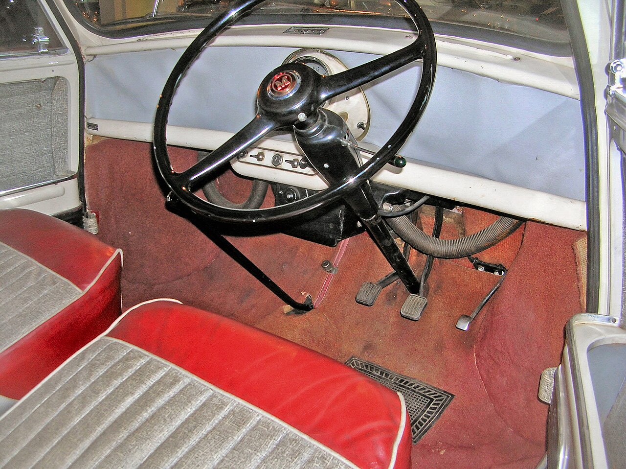 L'habitacle dépouillé d'une Mini de 1959 : un unique compteur central et un grand volant fin